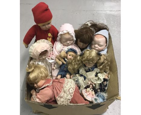 A box of modern ceramic collectors dolls to include sleeping babies and crawling baby with pillow.