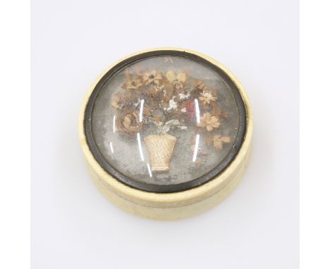 AN IVORY SNUFF BOX, LATE 18TH/EARLY 19TH CENTURY, circular, the glazed domed cover inset with a vase of flowers in relief. Di