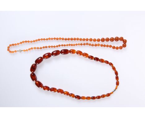 TWO STRINGS OF AMBER COLOURED BEAD NECKLACES, the first of graduating oval beads with screw clasp, 62.5cm, the second of grad