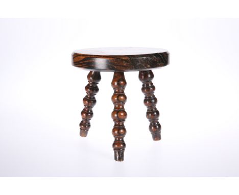 A 19th CENTURY GRAIN-PAINTED TREEN CANDLE STAND, modelled as a three-legged stool, with circular top and raised on bobbin-tur