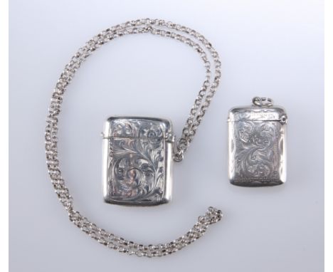 TWO EDWARDIAN SILVER VESTA CASES, the first Birmingham 1907 with foliate scroll engraving, on a silver hallmarked chain, the 
