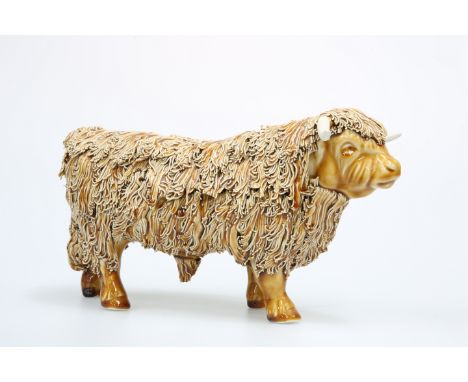 A POTTERY MODEL OF A HIGHLAND BULL, signed Craig Gilchrist, with shredded coat. 19cm high, 34cm long