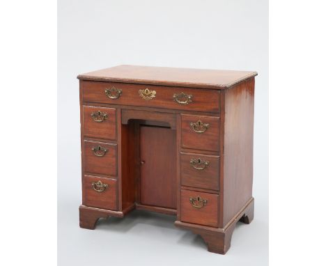 A GEORGE III MAHOGANY KNEEHOLE DESK, the moulded rectangular top with inverted corners, above a long drawer over two banks of