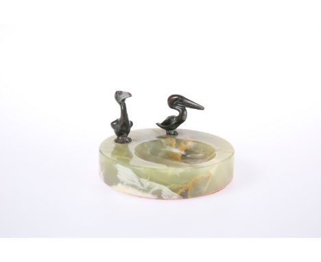 AN ONYX ASHTRAY MOUNTED WITH TWO BRONZE MODELS OF PELICANS. Diameter 10cm