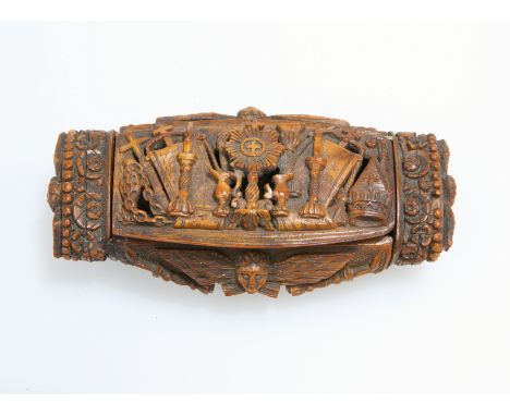 A 19TH CENTURY CARVED COQUILLA NUT SNUFF BOX,&nbsp;the hinged cover carved in relief with religious artefacts including a mon