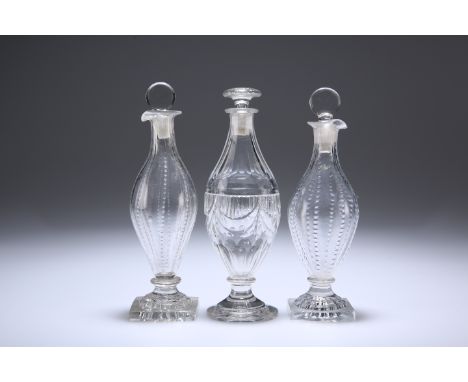 THREE ENGLISH GLASS CONDIMENT BOTTLES AND STOPPERS, CIRCA 1800, comprising a pair with "lemon squeezer" base and a single wit