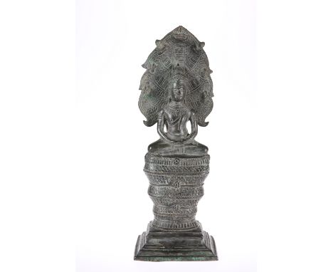 A CAMBODIAN BRONZE BUDDHA, seated with Naga, 18th Century. 33.5cm
