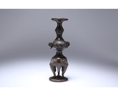 A CHINESE BRONZE STAND, of knopped baluster form, the dished top above a knop with zoomorphic handles, the base on legs cast 