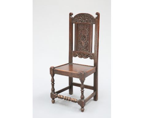 AN OAK PANEL-BACK CHAIR, LATE 17TH/EARLY 18TH CENTURY, the arched crest carved with an anthemion, above a panel centred by a 