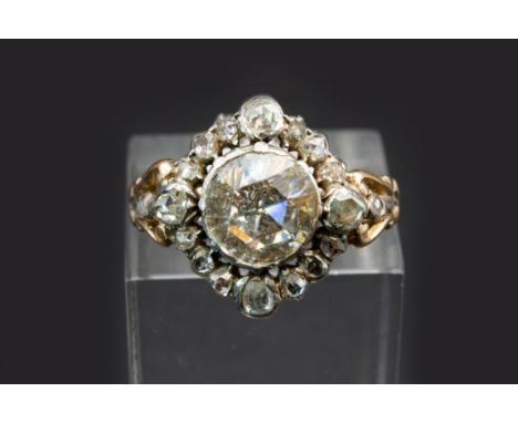 A GEORGIAN DIAMOND RING, the principle rose cut diamond set within a pierced work mount, between scroll detail shoulders, set