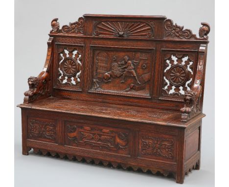 A LATE 19TH CENTURY CARVED OAK SETTLE, the crest centred by a panel carved with reeding between foliate and scroll carved spa