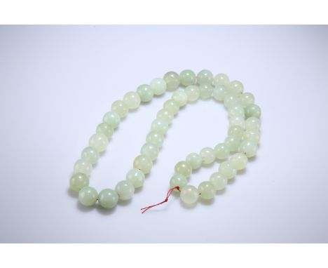 A STRING OF JADE BEADS, the forty-nine beads slightly graduating. Approx. 630 grams