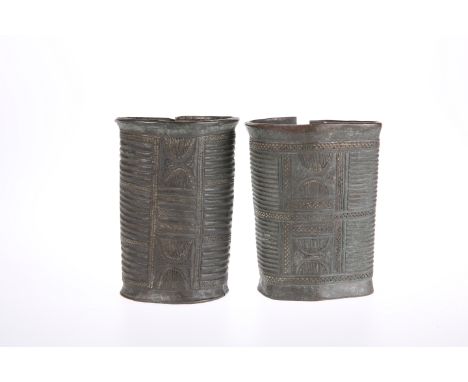 TWO BENIN BRONZE ARMLETS, of cylindrical form. 14.5cm high