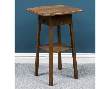 AN ARTS AND CRAFTS OAK OCCASIONAL TABLE, the shaped square moulded top above frieze with pierced motifs, raised on square-sec