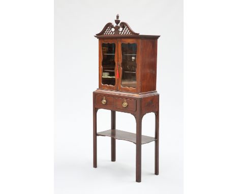 A MAHOGANY CABINET ON STAND, 18TH CENTURY AND LATER, the upper section with fret-carved swan-neck pediment centred by a flami