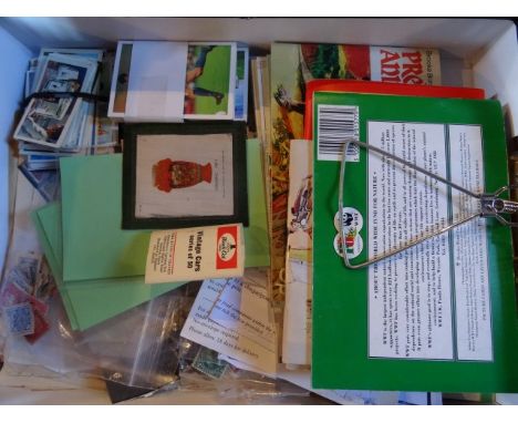 A box containing a quantity of used stamps, enamel pin badges, tea collector's cards and other similar items.
