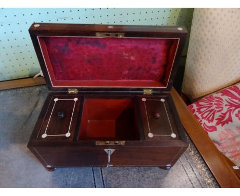 A rosewood tea caddy of sarcophagus form on four bun supports, having inlaid mother of pearl decoration with internal twin li