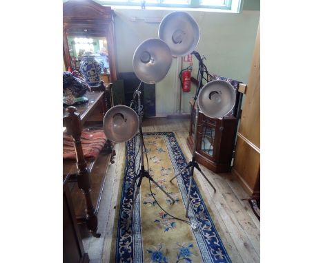 A pair of mid 20th century Kodak photographic spot lamps on tripod supports, each having two steel shades.