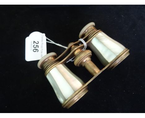 A pair of brass opera glasses, the barrels formed of mother of pearl, bearing the makers name Chevalier of Paris.