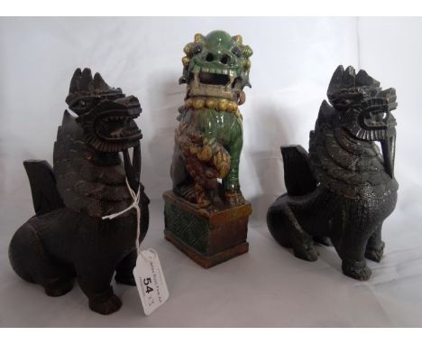 A pair of carved hardwood Chinese incense holders modelled as Dogs of Fo, together with a green and yellow glazed ceramic Dog
