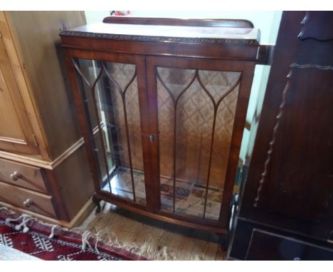 A 20th century display cabinet of bow front form on short cabriole supports, 85cm wide.