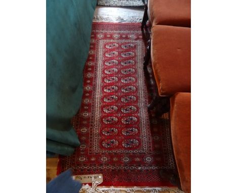 An early 20th century Turkish carpet, having large salmon pink central lozenge, decorated with stylized floral shapes within 