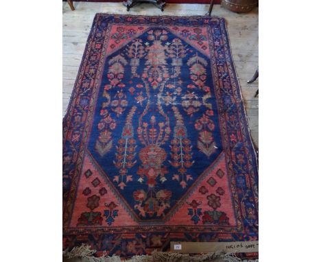 An Indian carpet, with blue central ground and pink corners within a dark blue border, 200cm x 170cm.