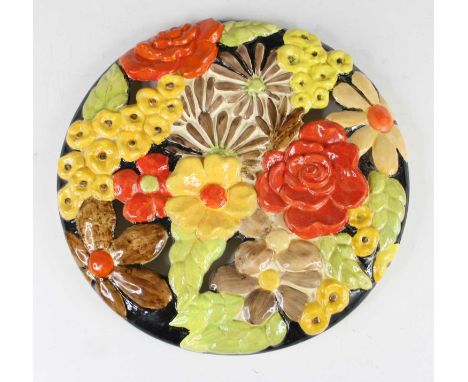 A 1930s Clarice Cliff pierced and moulded circular wall charger, all-over bright colour stylised floral decorated, backstamp 