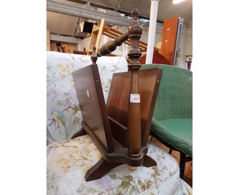 A WHITE STANDARD LAMP AND A MAGAZINE RACK