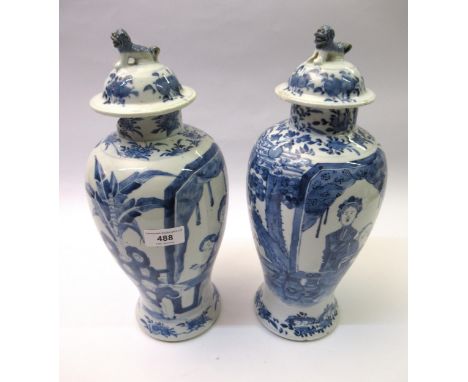 Pair of Chinese baluster form vases with covers, blue and white decorated with figures in gardens, 35cm high (with damages an