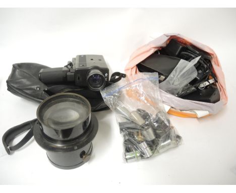 Box containing a quantity of various mixed camera accessories including large and small lenses, an early carbon filament ligh