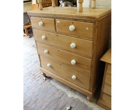 19th Century polished pine straight front chest of two short and three long drawers with white ceramic handles, raised on low