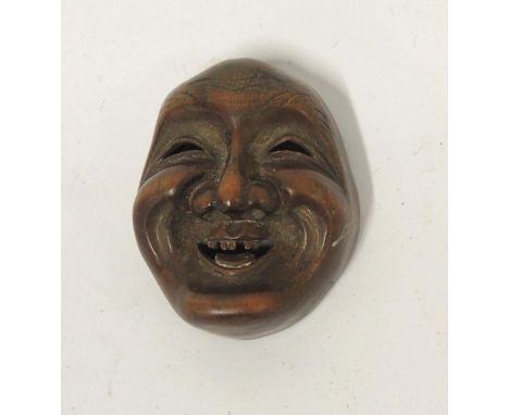 Japanese carved boxwood netsuke in the form of a maskhead, signed to the reverse 
