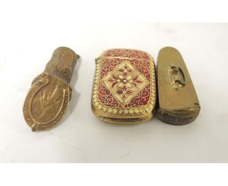 Brass vesta case in the form of a violin case, another in the form of a hoof and a gilt metal enamel decorated vesta case 