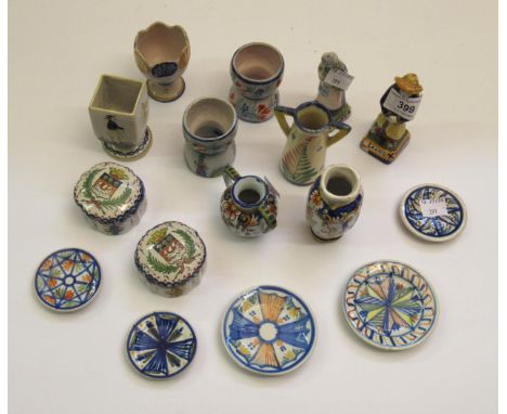 Two miniature Quimper pottery figures, two miniature vases, four miniature plates, four egg cups and two miniature covered bo