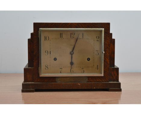 An oak cased art deco style mantle clock, rectangular dial, with a plaque beneath, 22cm H x 32cm W