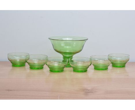 An art deco green glass fruit salad set, comprising a footed serving bowl centre-piece, 14.5cm high and six bowls 10.5cm diam