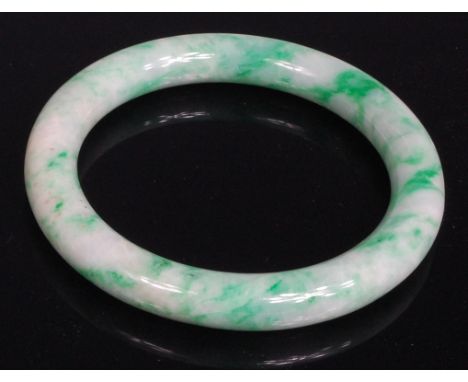 A Chinese celadon and green jade bangle, 9cm
