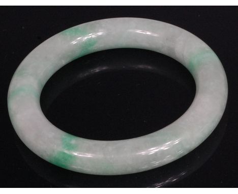A Chinese polished celadon and green jade bangle, 8.4cm