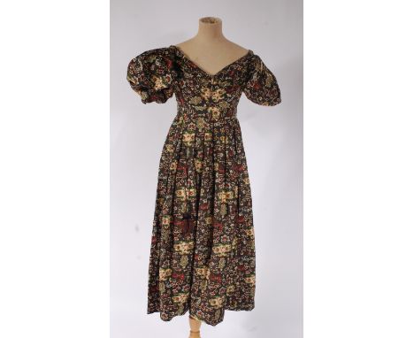 A circa 1830 printed cotton dress, having puffball sleeves and separate long undersleeves, with braid trim pockets and tassel