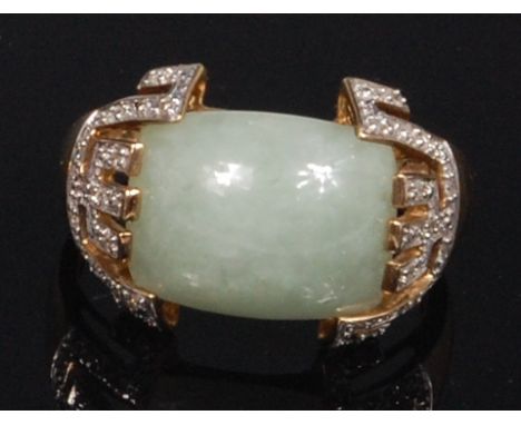 A modern 9ct gold, jade and diamond set dress ring, the central cabochon jade in Chinese influenced and pave small round cut 
