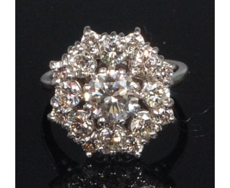 An 18ct white gold and diamond cluster ring, the centre claw set brilliant weighing 0.85ct, in a surround of eight smaller br