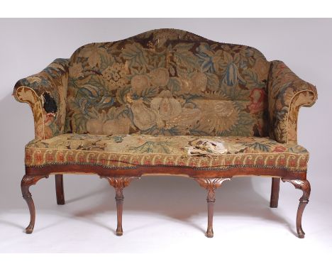 A walnut framed camel-back settee, in the Queen Anne style, probably Dutch 18th century, upholstered and close nailed in 18th