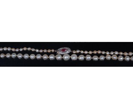 A graduated and knotted pearl single string necklace, having Art Deco white metal, ruby and diamond set clasp, 47cm, the larg