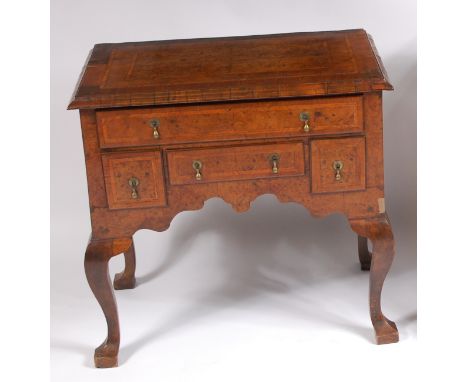 An early 18th century walnut and burr walnut lowboy, the four quarter veneered top with feather and crossbanding above an arr