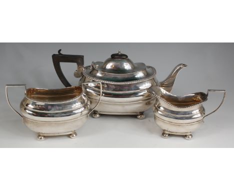 A Regency style silver three piece tea service, comprising; teapot, twin handled sugar and cream, each of oval bombe form, wi