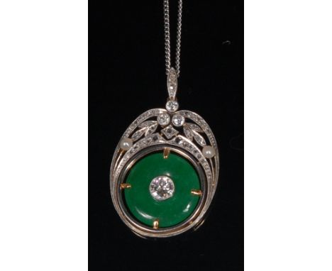 An early 20th century yellow metal, jade and diamond pendant, the central green jade disc set with a single brilliant cut dia
