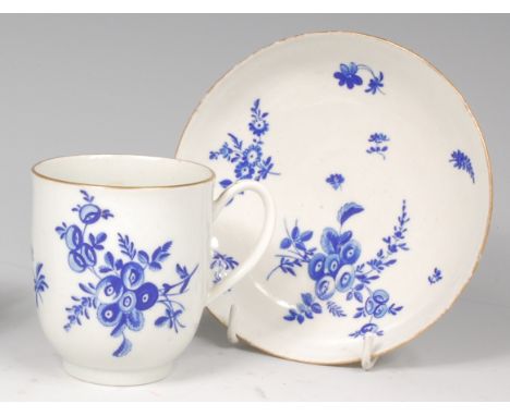 A first period Worcester coffee cup and saucer, polychrome decorated in blue with sprays of flowers on a white ground, gilt b