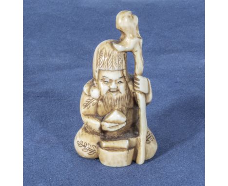 An antique netsuke depicting a sage with a staff, 1.25"