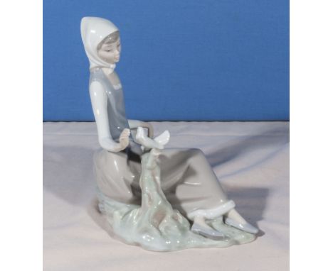 A Lladro figure of a girl holding a dove